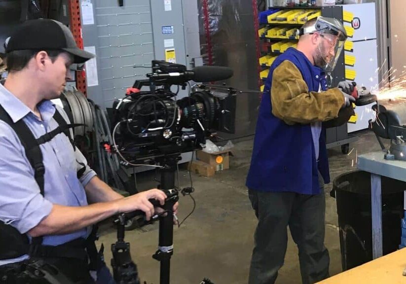 a man holding a camera for a boston video producton